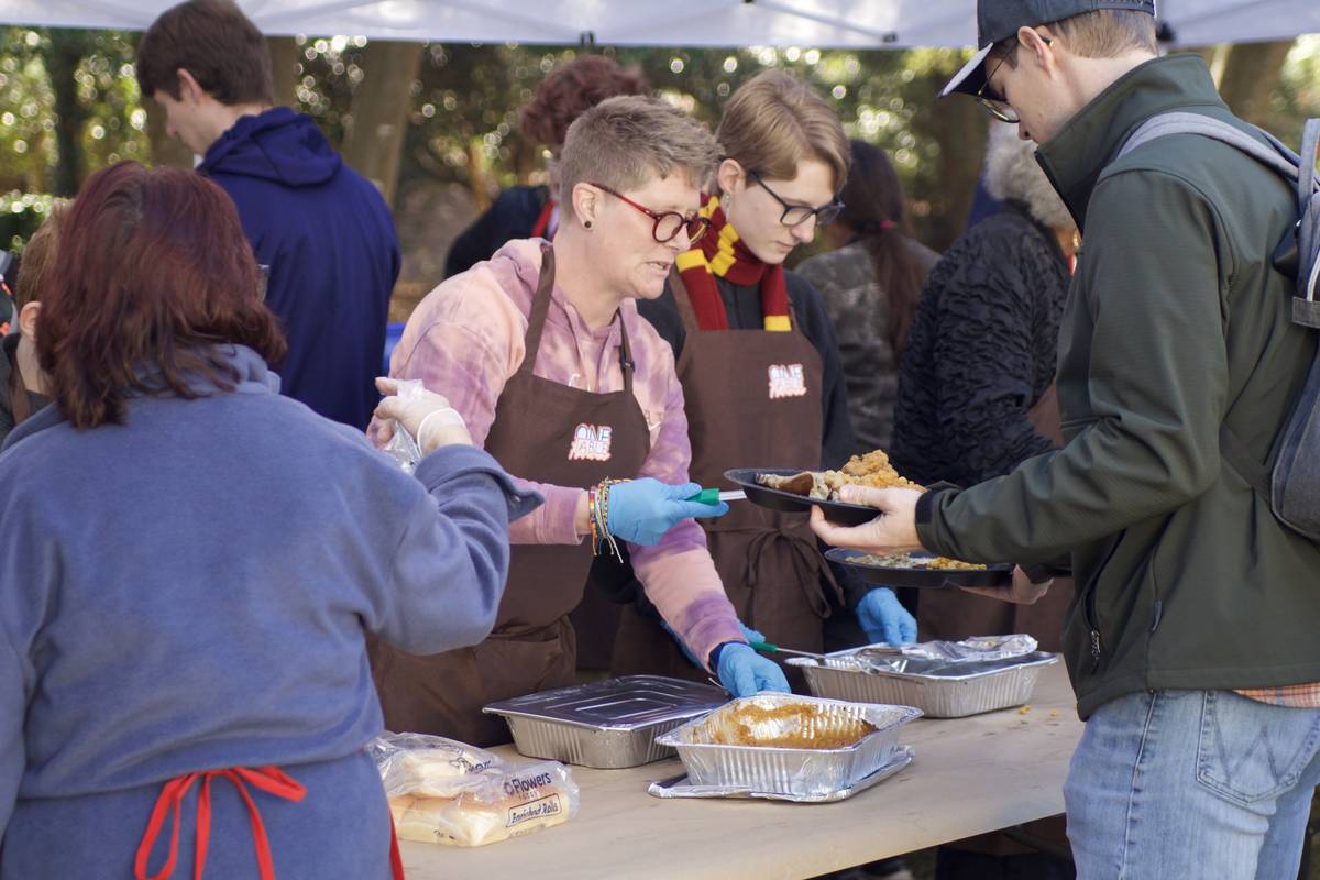 Volunteers plating casseroles along the serving line at One Table Florence.